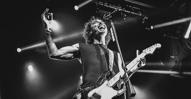 grayscale photo of man playing the guitar and singing