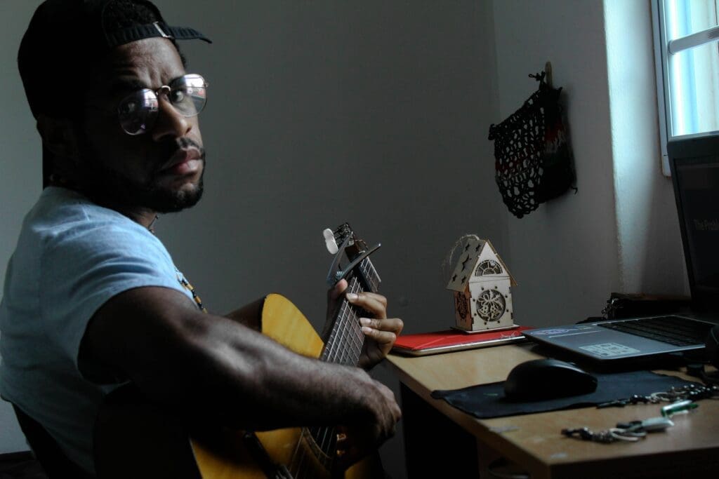 Guitarist playing his instrument looks into the camera